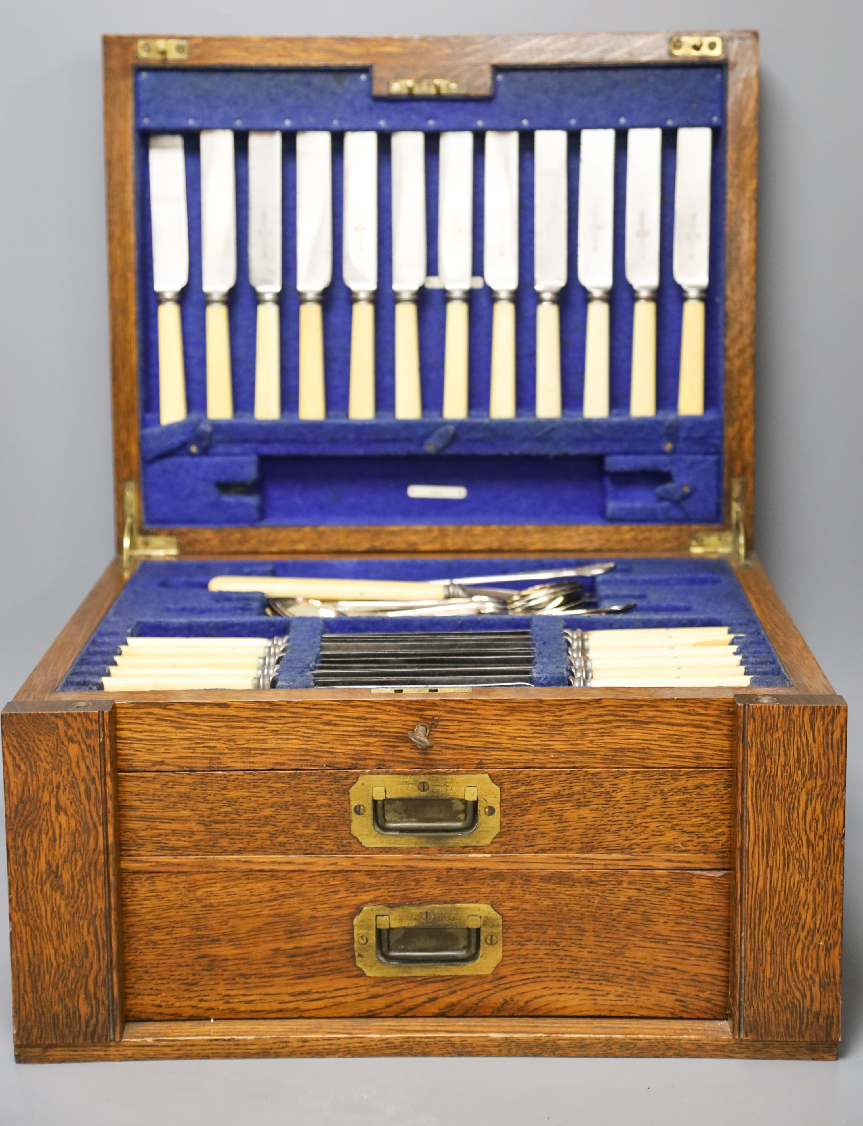 An Edwardian oak cased canteen of plated Kings pattern cutlery